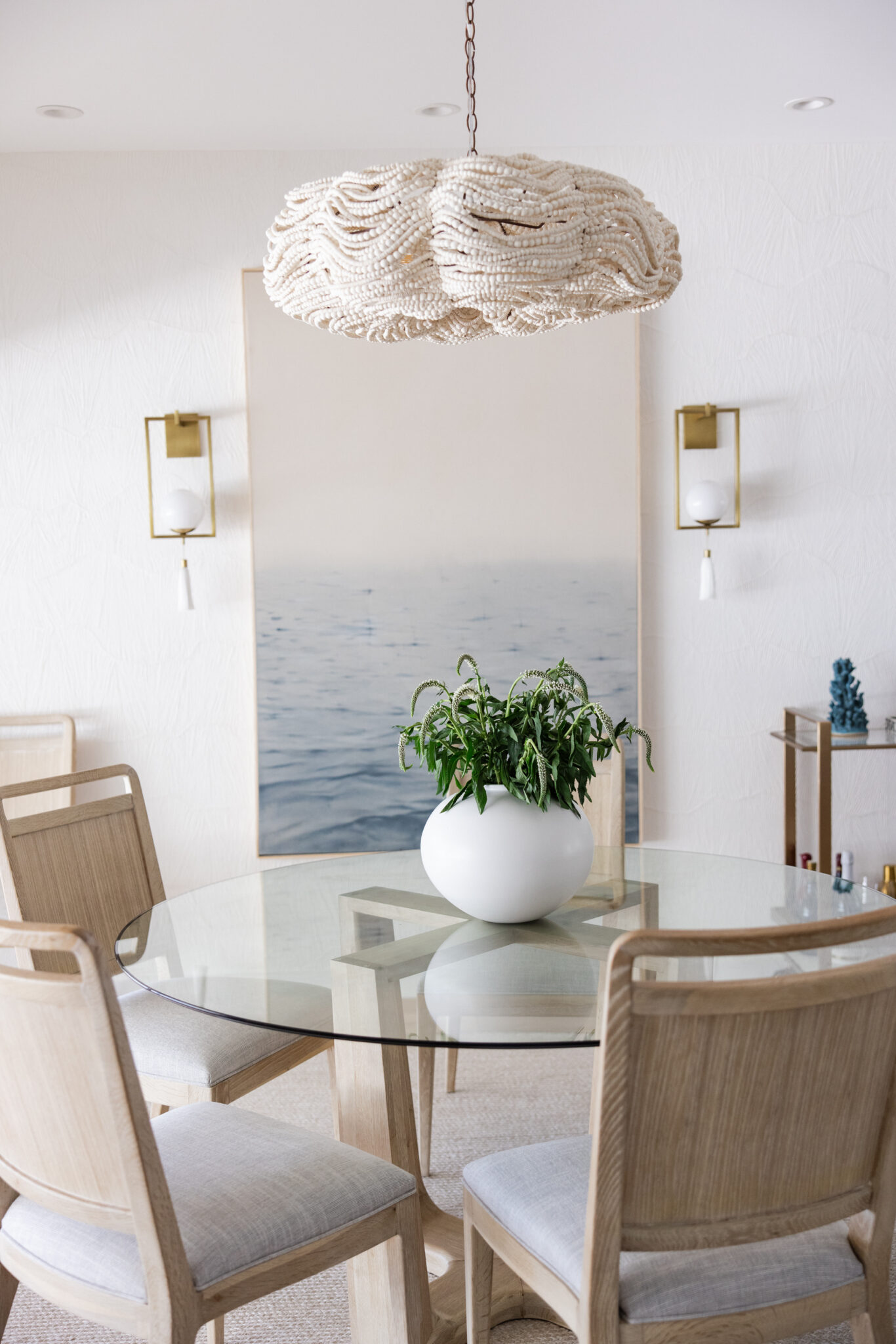 kitchen table with beaded chandelier and ocean photograph