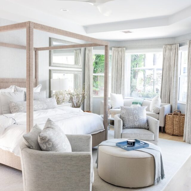 Serene primary bedroom with four-poster bed, neutral seating area, light drapery, and soft layered textures.